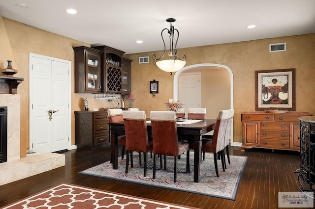 dining space featuring a fireplace and dark wood-type flooring