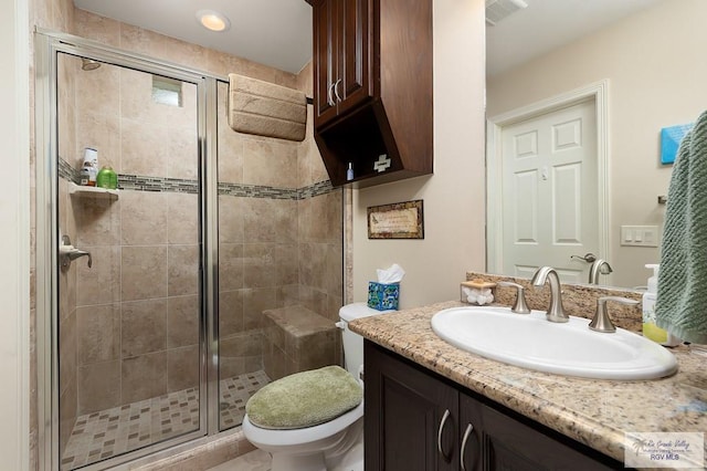 bathroom featuring an enclosed shower, vanity, and toilet