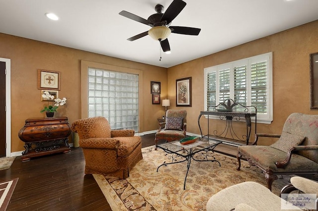 living area featuring wood-type flooring and ceiling fan