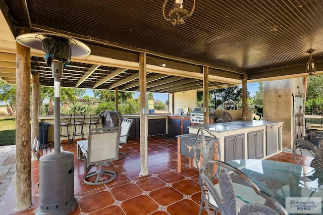 view of patio / terrace featuring area for grilling, an outdoor kitchen, and an outdoor bar