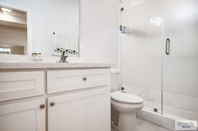 bathroom featuring vanity, toilet, and a shower with shower door