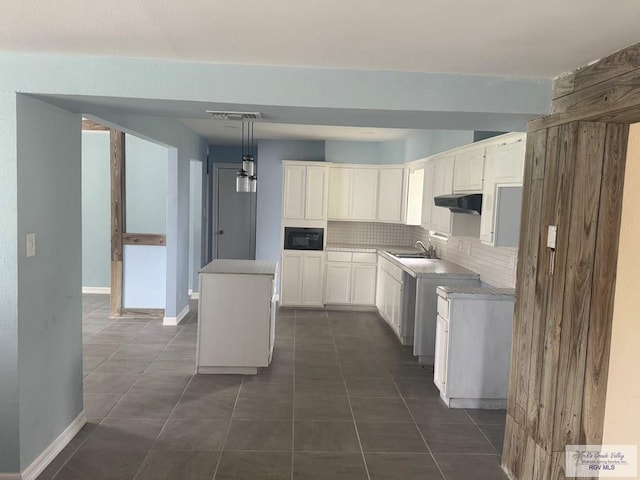 44 Highland Ter, Brownsville, TX 78521 - kitchen featuring a sink, tasteful backsplash, black microwave, and dark tile patterned flooring