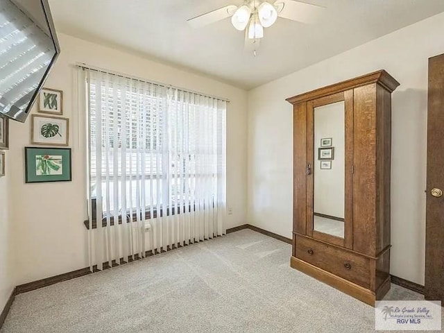 unfurnished bedroom featuring ceiling fan and light colored carpet