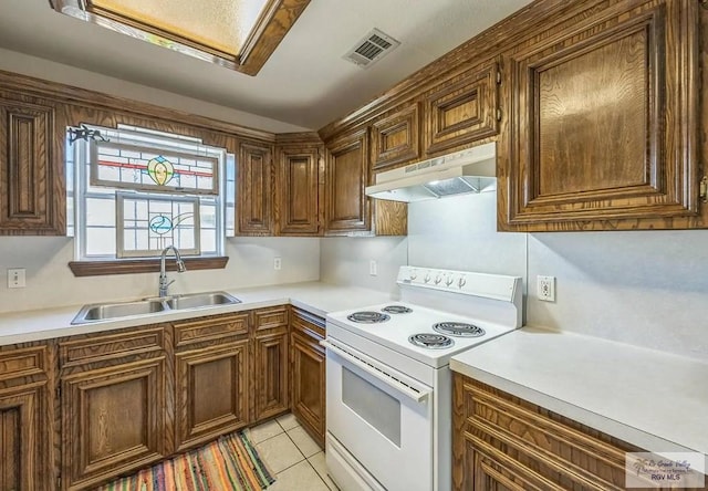 kitchen with light tile patterned floors, sink, and electric range