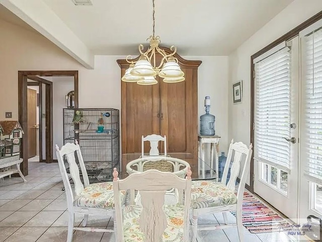 dining area featuring light tile patterned flooring and an inviting chandelier