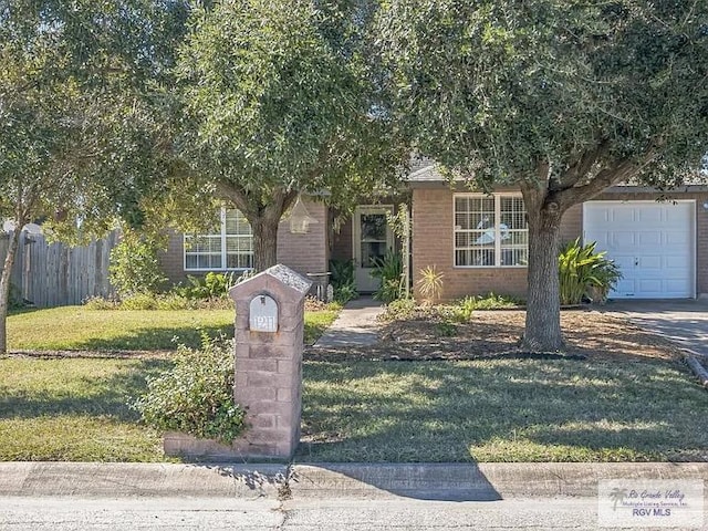 view of property hidden behind natural elements with a garage and a front lawn