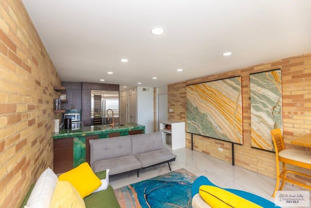 living room featuring brick wall and recessed lighting
