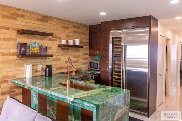 kitchen featuring light tile patterned floors, appliances with stainless steel finishes, a peninsula, open shelves, and recessed lighting