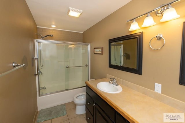 bathroom featuring toilet, vanity, enclosed tub / shower combo, and tile patterned floors