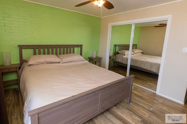 bedroom with baseboards, a ceiling fan, ornamental molding, wood finished floors, and a closet