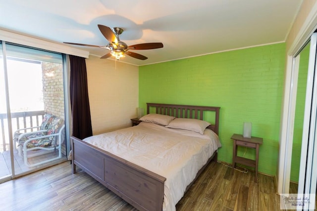 bedroom featuring a closet, a ceiling fan, brick wall, wood finished floors, and access to outside