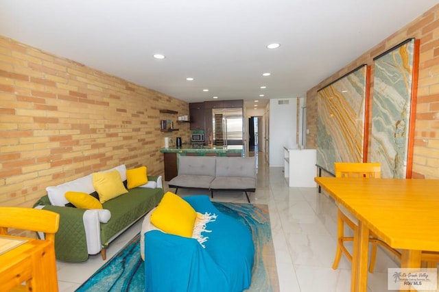 living area with recessed lighting, visible vents, and brick wall