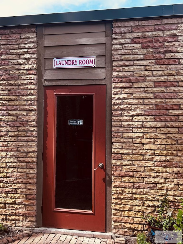 doorway to property featuring stone siding and brick siding