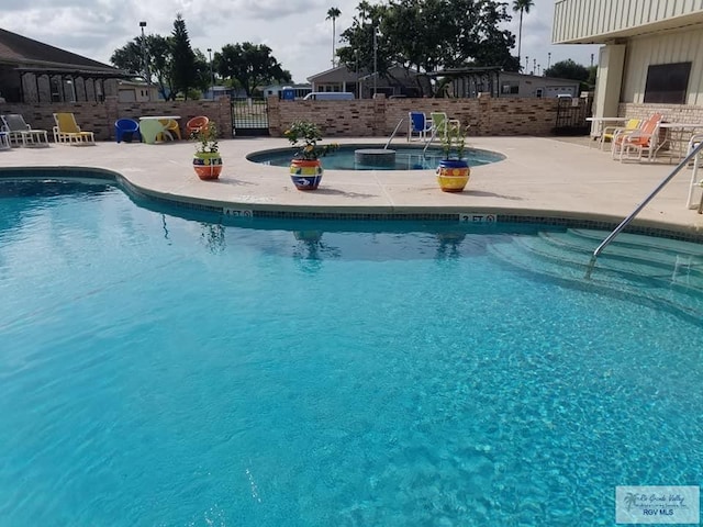 community pool with fence and a patio