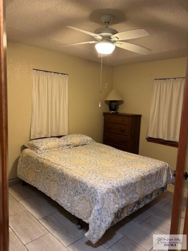bedroom with a textured ceiling and ceiling fan