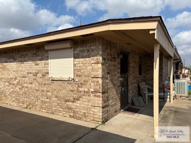 view of home's exterior with a patio and brick siding
