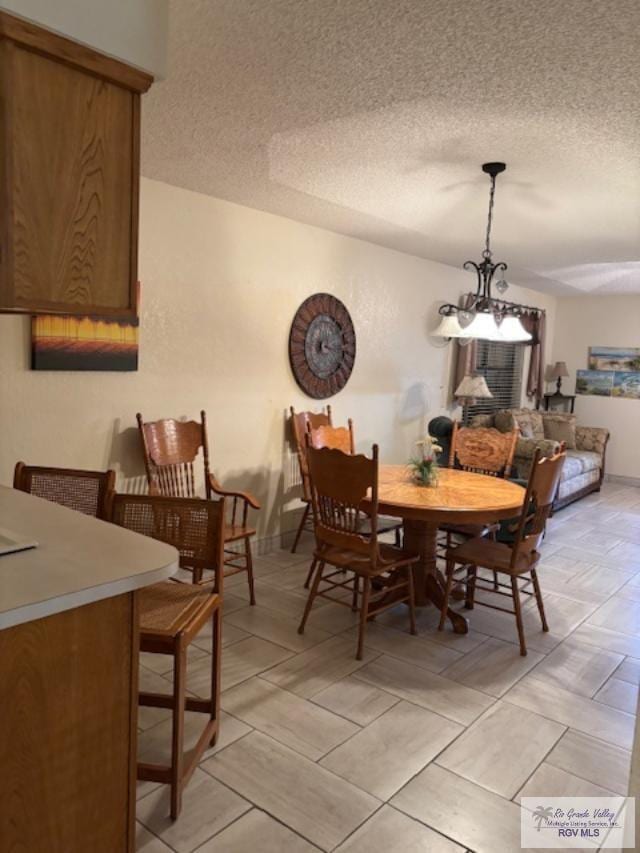 dining area featuring a notable chandelier and a textured ceiling