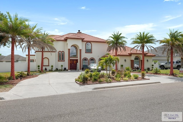 5454 Dragon Wick, Brownsville, TX 78526 - mediterranean / spanish home featuring stucco siding, a tile roof, concrete driveway, and a chimney