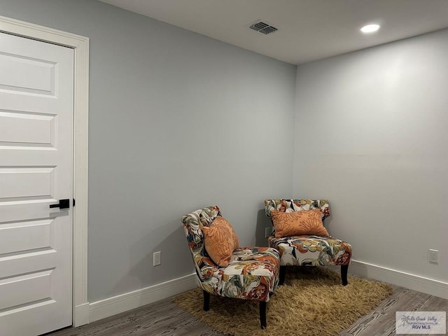 living area with baseboards, visible vents, wood finished floors, and recessed lighting