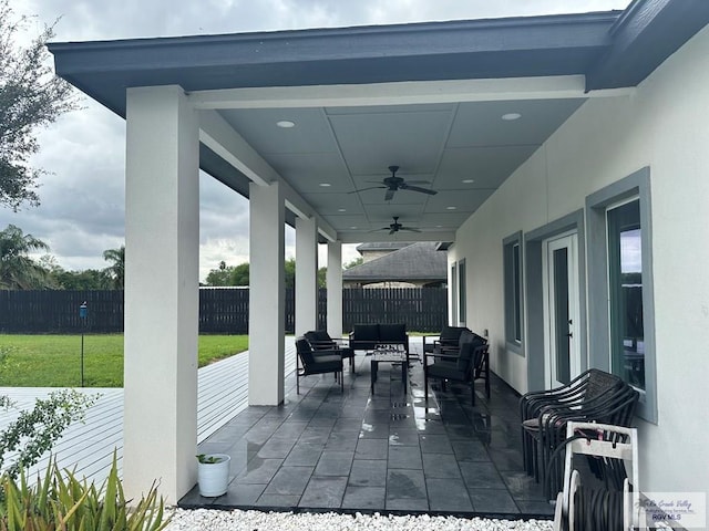 view of patio featuring ceiling fan, an outdoor living space, and a fenced backyard