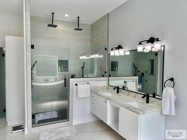 full bath featuring double vanity, a stall shower, and a sink