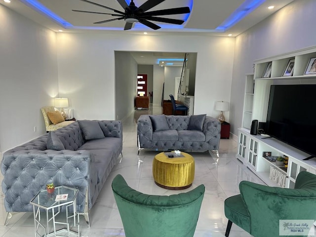 living room featuring ceiling fan, baseboards, a raised ceiling, and recessed lighting