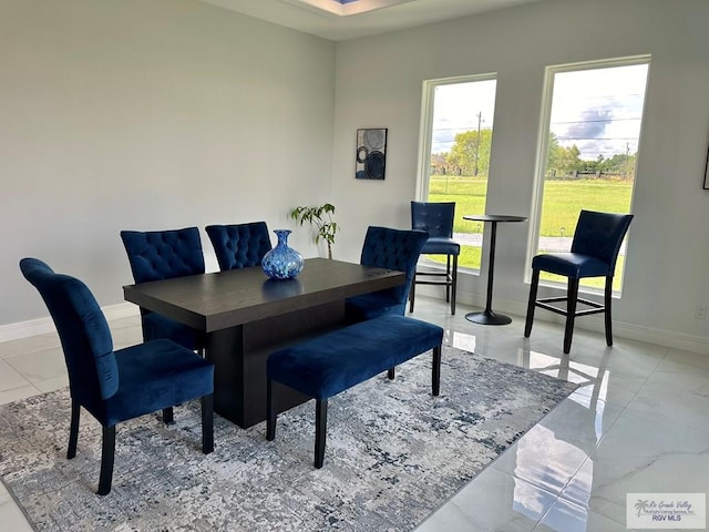 dining area featuring marble finish floor and baseboards