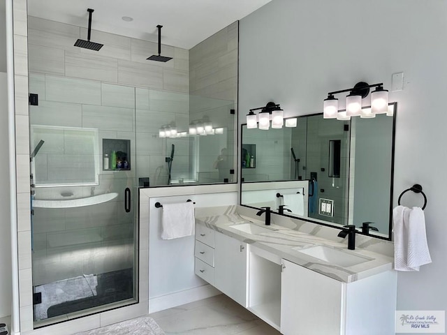 full bathroom with marble finish floor, double vanity, a sink, and a shower stall