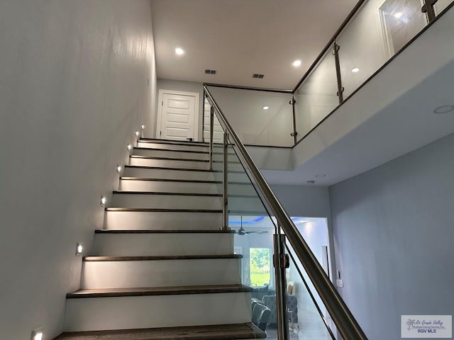 stairs featuring recessed lighting, visible vents, and a high ceiling