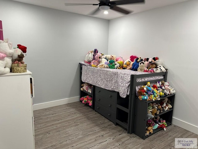 bedroom with ceiling fan, wood finished floors, and baseboards