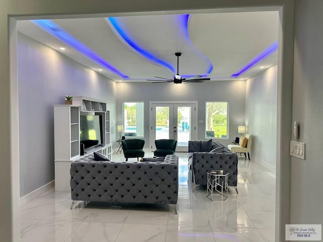 living area featuring baseboards, a raised ceiling, ceiling fan, marble finish floor, and french doors