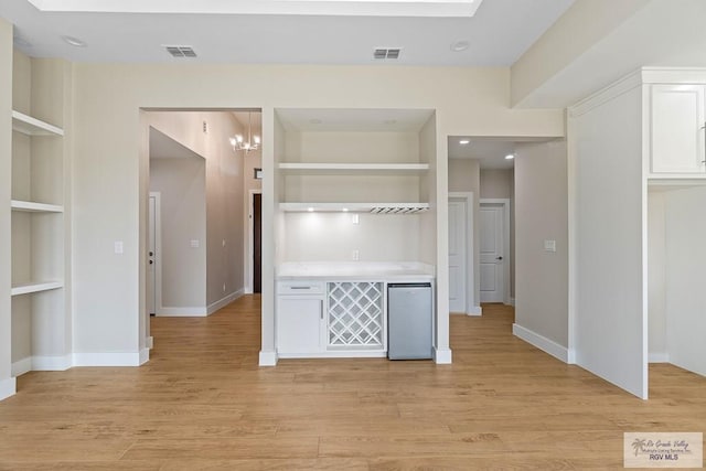 kitchen with a skylight, light hardwood / wood-style flooring, and built in shelves