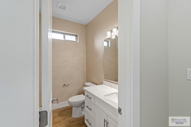 bathroom featuring vanity, wood-type flooring, and toilet