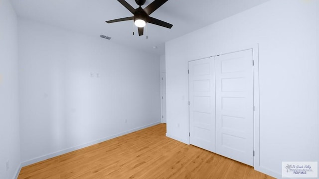 unfurnished bedroom featuring ceiling fan, light hardwood / wood-style floors, and a closet