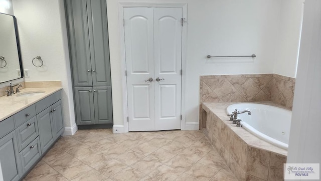 bathroom featuring vanity and a relaxing tiled tub