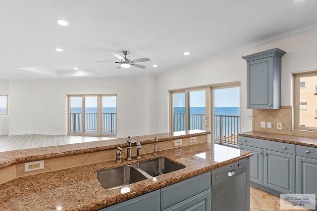 kitchen with stainless steel dishwasher, plenty of natural light, a water view, and sink