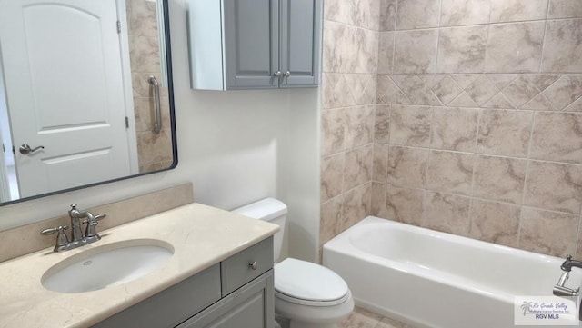 full bathroom with tiled shower / bath, vanity, and toilet