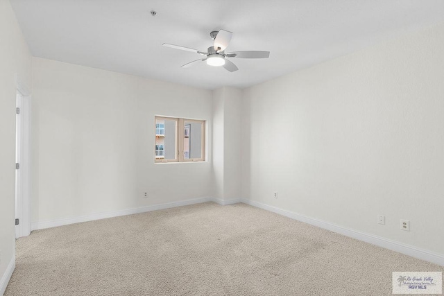 spare room with ceiling fan and light carpet