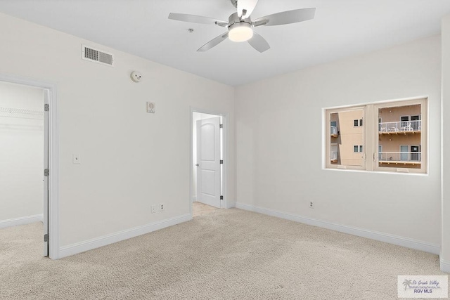 carpeted spare room with ceiling fan