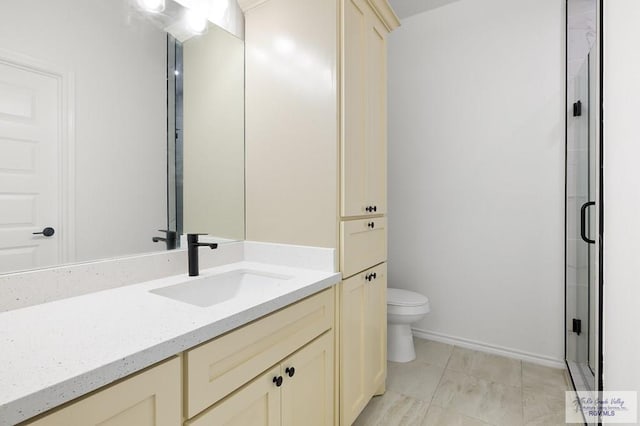 bathroom featuring a shower with door, vanity, tile patterned floors, and toilet