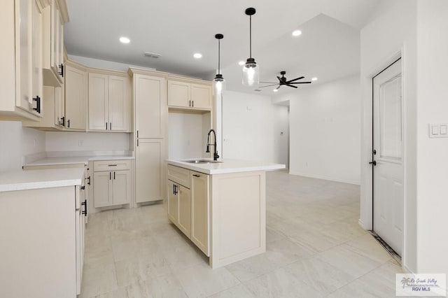 kitchen featuring sink, a center island with sink, pendant lighting, ceiling fan, and cream cabinets