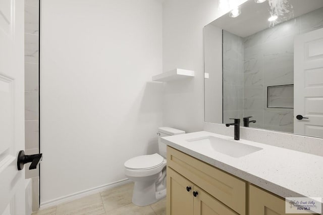 bathroom with tiled shower, vanity, and toilet