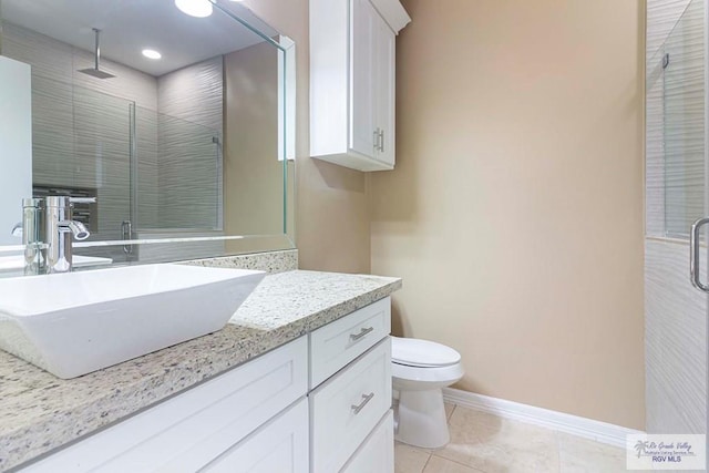 bathroom featuring tile patterned floors, vanity, toilet, and an enclosed shower