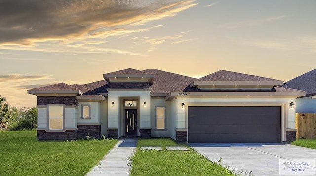 prairie-style home featuring a yard and a garage