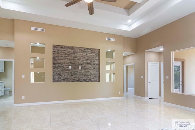 unfurnished room with ceiling fan and a high ceiling