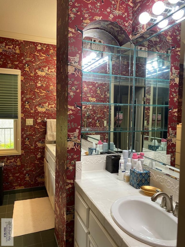 bathroom with tile patterned flooring, vanity, baseboards, and wallpapered walls