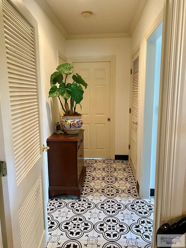 corridor featuring light tile patterned floors and ornamental molding