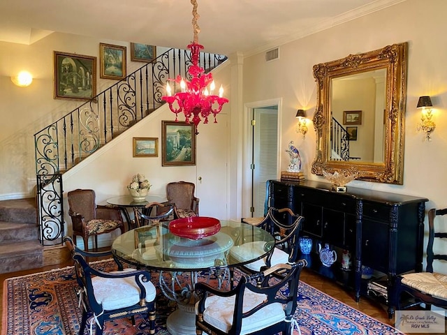 dining area with visible vents, stairs, ornamental molding, and a chandelier