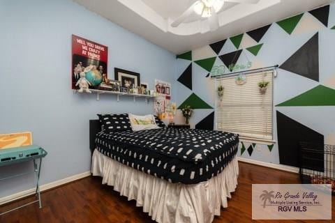 bedroom featuring a tray ceiling and dark wood-type flooring