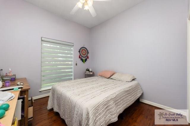 bedroom with dark hardwood / wood-style flooring, vaulted ceiling, and ceiling fan